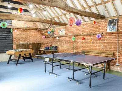 a ping pong table in a room with a brick wall at The Granary in Colchester