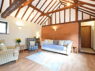 a living room with a couch and a brick wall at The Stables in Colchester