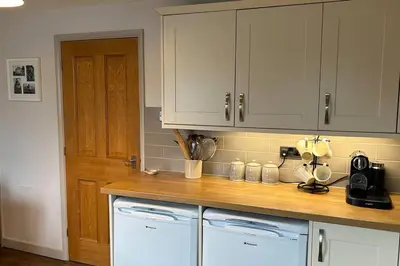 a kitchen with white cabinets and two washer and dryer at Cosy 2 bed, home from home in Haddenham