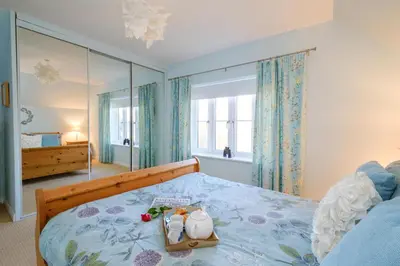 a bedroom with a bed with a blue bedspread at The Quarter Deck in Aldeburgh