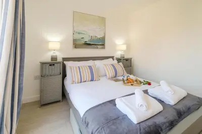 a bedroom with a large white bed with towels on it at The Garden Flat in Aldeburgh