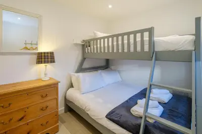 a bedroom with a bunk bed and a mirror at The Garden Flat in Aldeburgh