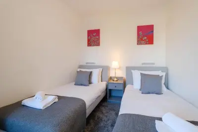two twin beds in a room with white walls at 39 Carr Avenue - Aldeburgh Coastal Cottages in Leiston