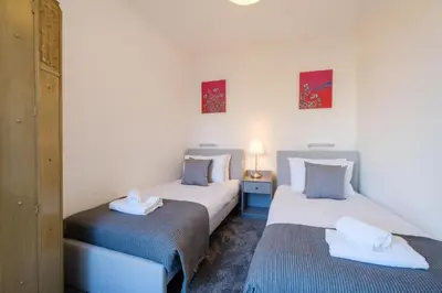 two twin beds in a room with two towels at 39 Carr Avenue - Aldeburgh Coastal Cottages in Leiston