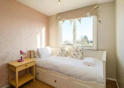 a small bedroom with a bed and a window at 61 Fairfield Road in Aldeburgh