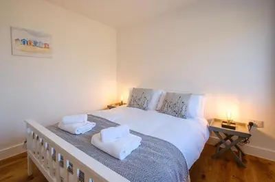 a bedroom with a large white bed with towels on it at Three Tuns - Garden Suite 1 in Wickham Market