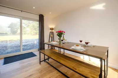a dining room with a table and a bench at Three Tuns - Garden Suite 1 in Wickham Market