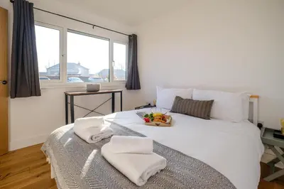 a bedroom with a white bed with a bowl of fruit on it at Three Tuns - Garden Suite 2 in Wickham Market
