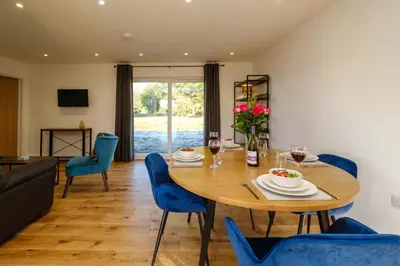 a dining room with a wooden table and blue chairs at Three Tuns - Garden Suite 2 in Wickham Market