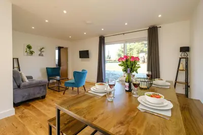 a dining room and living room with a table and chairs at Three Tuns - Garden Suite 3 in Wickham Market