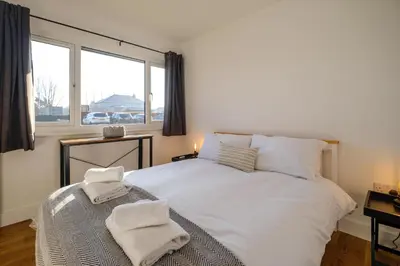 a bedroom with a white bed with two towels on it at Three Tuns - Garden Suite 3 in Wickham Market