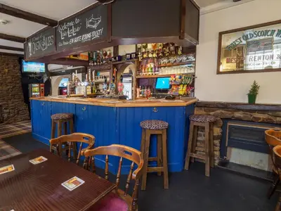 a bar in a restaurant with wooden stools at The Live and Let Live in Downham Market