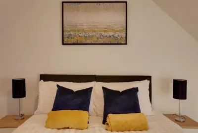 a bedroom with a bed with two pillows and a painting at Towerview Apartments Braintree in Braintree