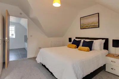 a bedroom with a large white bed with orange pillows at Towerview Apartments Braintree in Braintree