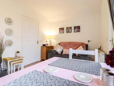 a bedroom with a pink bed and a living room at Rector's Retreat in Ipswich