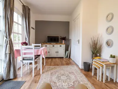 a living room with a table and a tv at Rector's Retreat in Ipswich