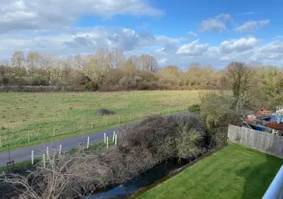 a view of a field and a road and a river at Contemporary, Cosy & Homely 2 Bed Apartment with High-Speed WIFI, Terrace & Free Parking overlooking Stourbridge Common Park & Coldham's Brook in Cambridge