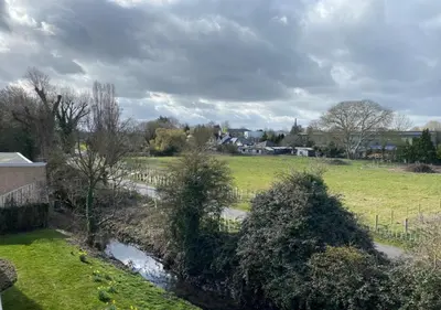 a view of a field and a creek in a yard at Contemporary, Cosy & Homely 2 Bed Apartment with High-Speed WIFI, Terrace & Free Parking overlooking Stourbridge Common Park & Coldham's Brook in Cambridge