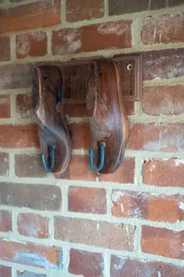 two pairs of shoes hanging on a brick wall at Alde Bay Farm - Oyster Catcher in Aldeburgh