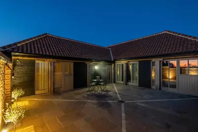 a house with a patio at night at Alde Bay Farm - Coral Cottage in Aldeburgh