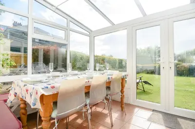 a conservatory with a table and chairs and windows at 4 Bed in Aldeburgh oc-al123 in Aldeburgh