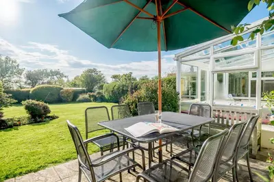 a table and chairs with an umbrella on a patio at 4 Bed in Aldeburgh oc-al123 in Aldeburgh