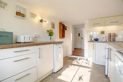 a kitchen with white cabinets and a counter top at 4 Bed in Aldeburgh oc-al123 in Aldeburgh