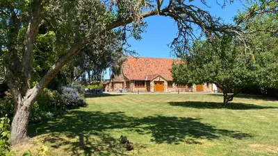 a house with a red roof and a yard with trees at Ye Olde Plough House in East Horndon