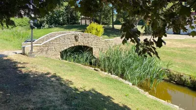a stone bridge over a pond in a park at Ye Olde Plough House in East Horndon