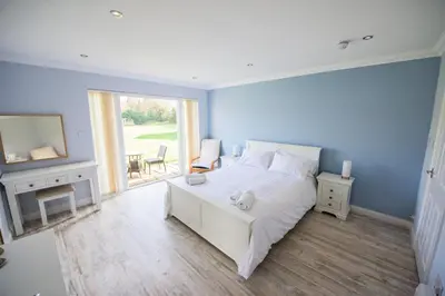 a bedroom with a white bed and a large window at Ye Olde Plough House in East Horndon