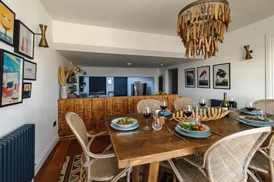 a dining room with a wooden table and chairs at Pembroke in Aldeburgh