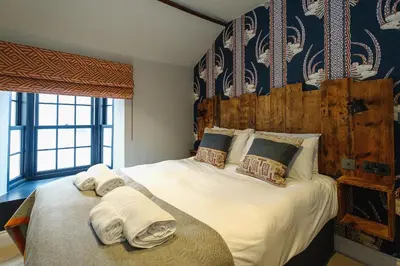 a bedroom with a large bed with towels on it at Pembroke in Aldeburgh