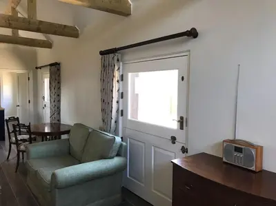 a living room with a couch and a sliding door at The Stables in Colchester