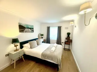 a bedroom with a bed and a window at Kiwi Tree Serviced Apartment in Cambridge