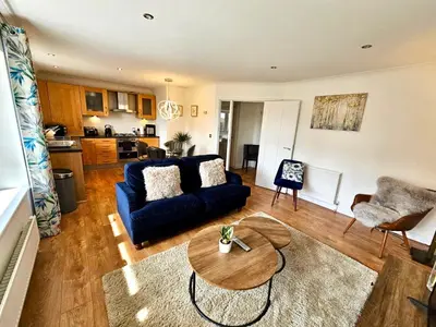 a living room with a blue couch and a table at Kiwi Tree Serviced Apartment in Cambridge