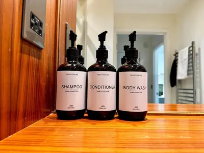 three bottles of wine sitting on a wooden counter at Kiwi Tree Serviced Apartment in Cambridge