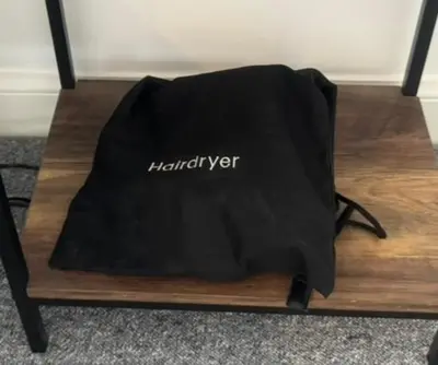 a black bag sitting on top of a wooden table at Kiwi Tree Serviced Apartment in Cambridge