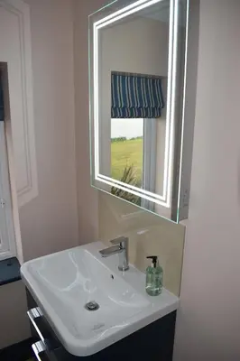 a bathroom with a sink and a mirror at River View - Stunning estuary views in Aldeburgh