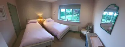 a small room with two beds and a mirror at River View - Stunning estuary views in Aldeburgh