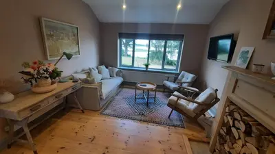 a living room with a couch and a fireplace at River View - Stunning estuary views in Aldeburgh