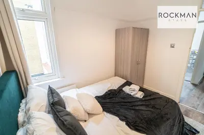 a baby laying on a bed in a room at 5 Bed Apartment Close To Beach with Off-street parking - Perfect for Contractors - Fast Wi-Fi - Close to beach in Southend-on-Sea