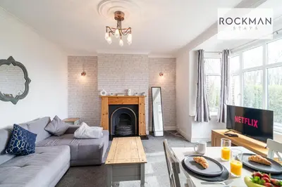 a living room with a couch and a fireplace at 5 Bed Apartment Close To Beach with Off-street parking - Perfect for Contractors - Fast Wi-Fi - Close to beach in Southend-on-Sea