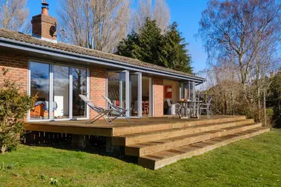 a house with a large wooden deck at Lowlands in Thorpeness