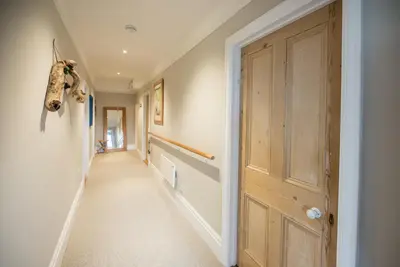 a hallway of a home with a wooden door at 3 St Nicholas Court, Aldeburgh in Aldeburgh