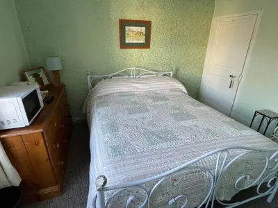 a small bedroom with a bed and a microwave at The Bridge Street Historic Guest House in Sudbury