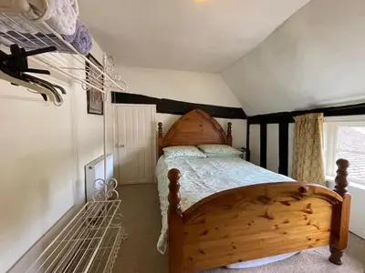 a bedroom with a wooden bed in a room at The Bridge Street Historic Guest House in Sudbury