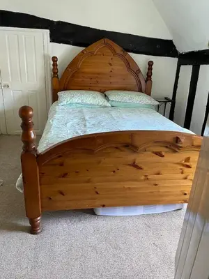 a wooden bed with two pillows on top of it at The Bridge Street Historic Guest House in Sudbury