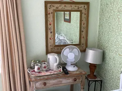 a dressing table with a mirror and a fan at The Bridge Street Historic Guest House in Sudbury