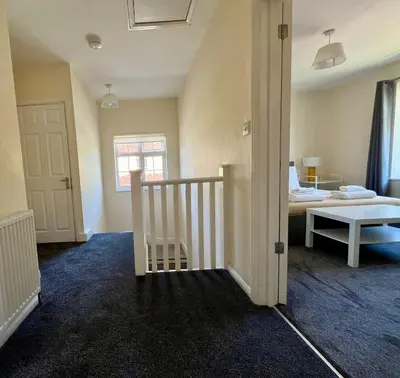 a bedroom with a bed and a stairway leading to a room at CENTRAL, newly refurb 2 bed flat with FREE PARKING in Cambridge