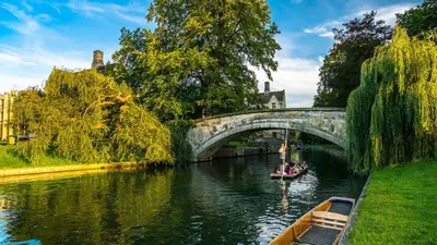a boat traveling down a river under a bridge at CENTRAL, newly refurb 2 bed flat with FREE PARKING in Cambridge